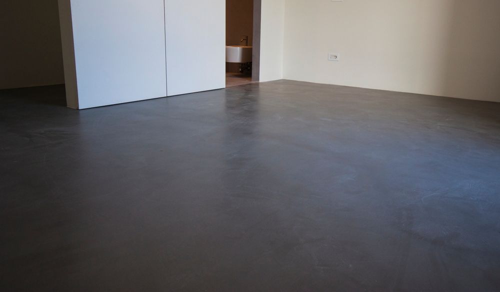 An Empty Room With a Concrete Floor and White Walls — Brett Rayner Cement Rendering In Murwillumbah, NSW