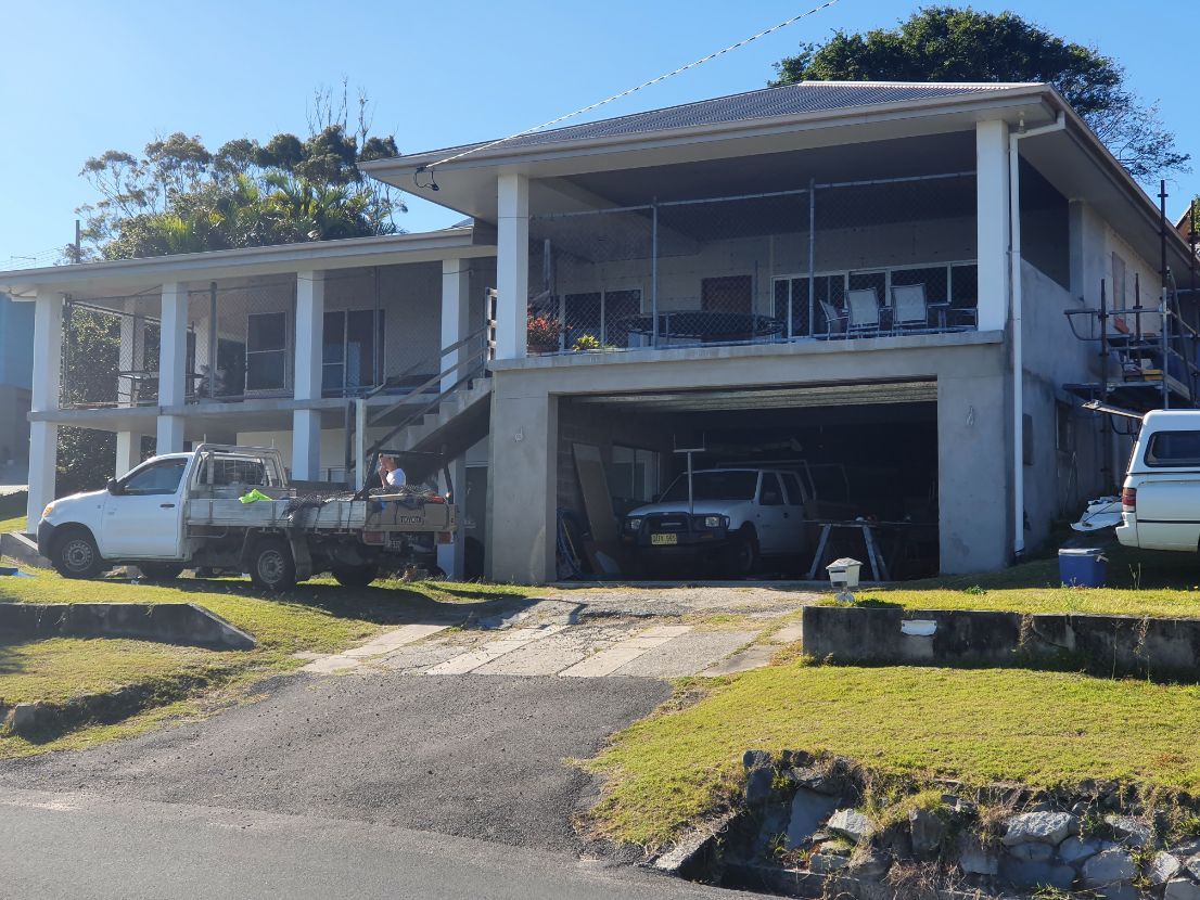 A White Truck is Parked in Front of a Large House — Brett Rayner Cement Rendering In Lismore, NSW