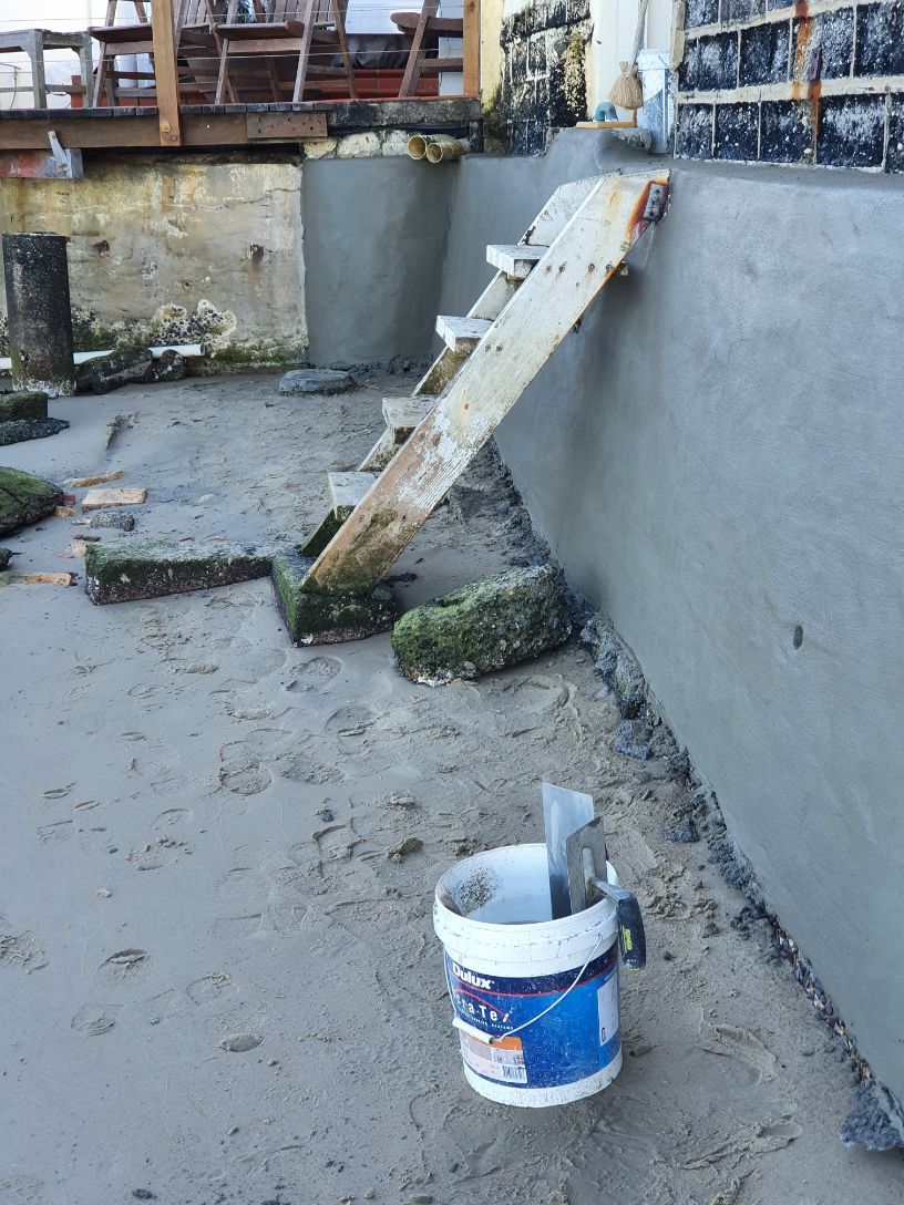 A Bucket of Paint is Sitting on the Ground Next to a Wall — Brett Rayner Cement Rendering In Goonellabah, NSW