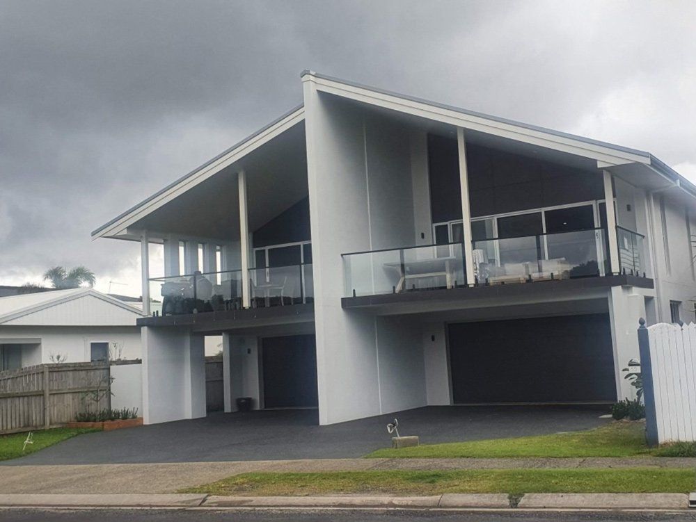 A Large White House With a Lot of Windows and Balconies — Brett Rayner Cement Rendering In Goonellabah, NSW