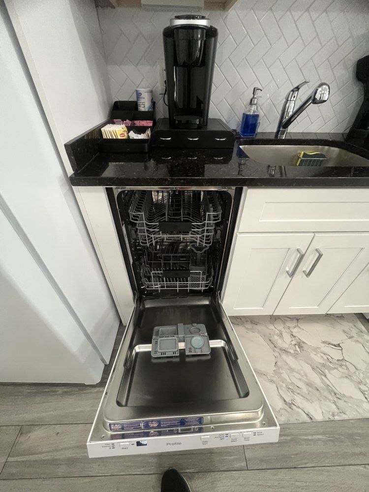 A dishwasher is open in a kitchen next to a sink.