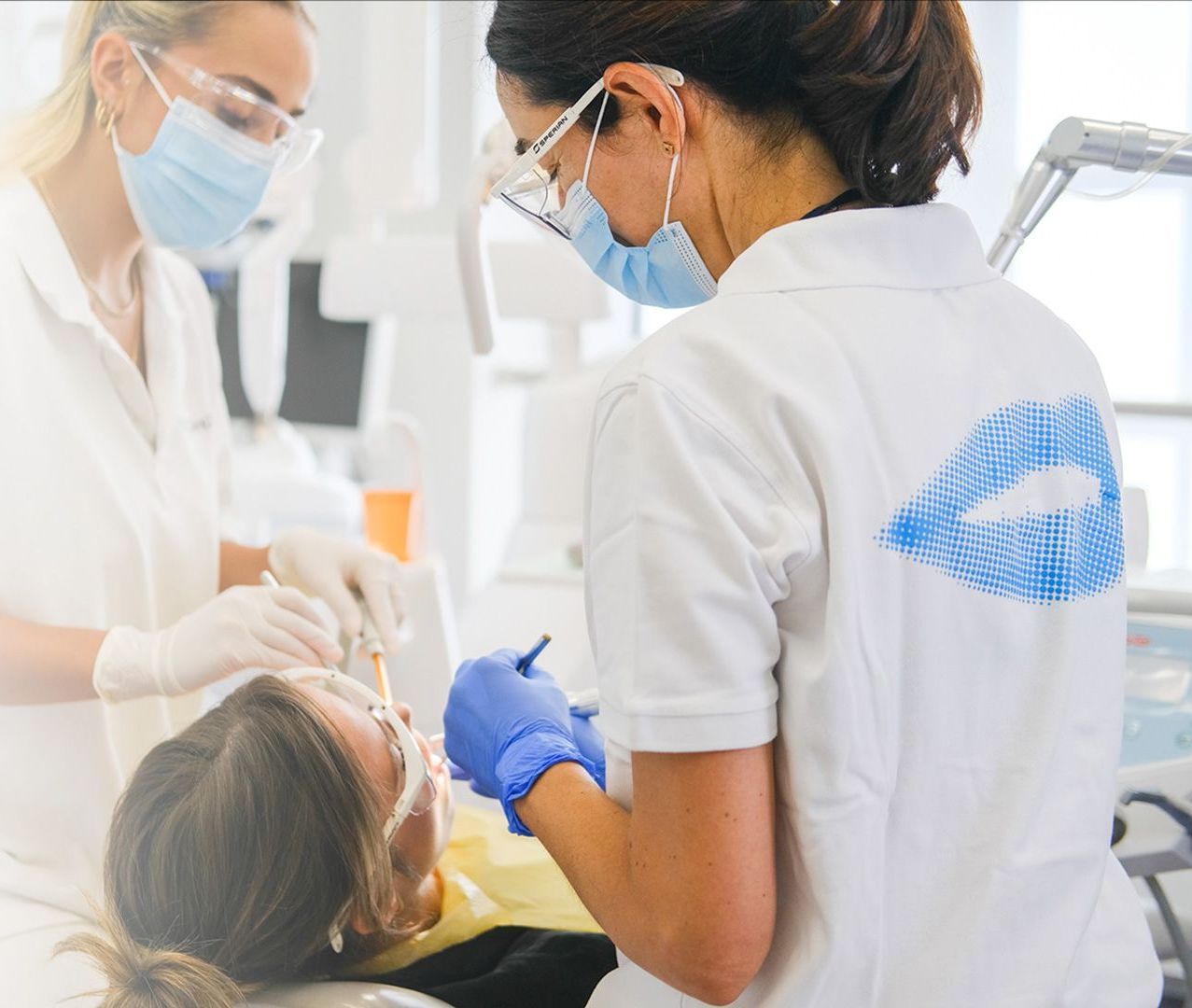 A woman is getting her teeth examined by a dentist
