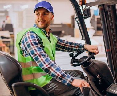 Un hombre conduce una carretilla elevadora en un almacén.