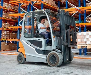Un hombre conduce una carretilla elevadora en un almacén.
