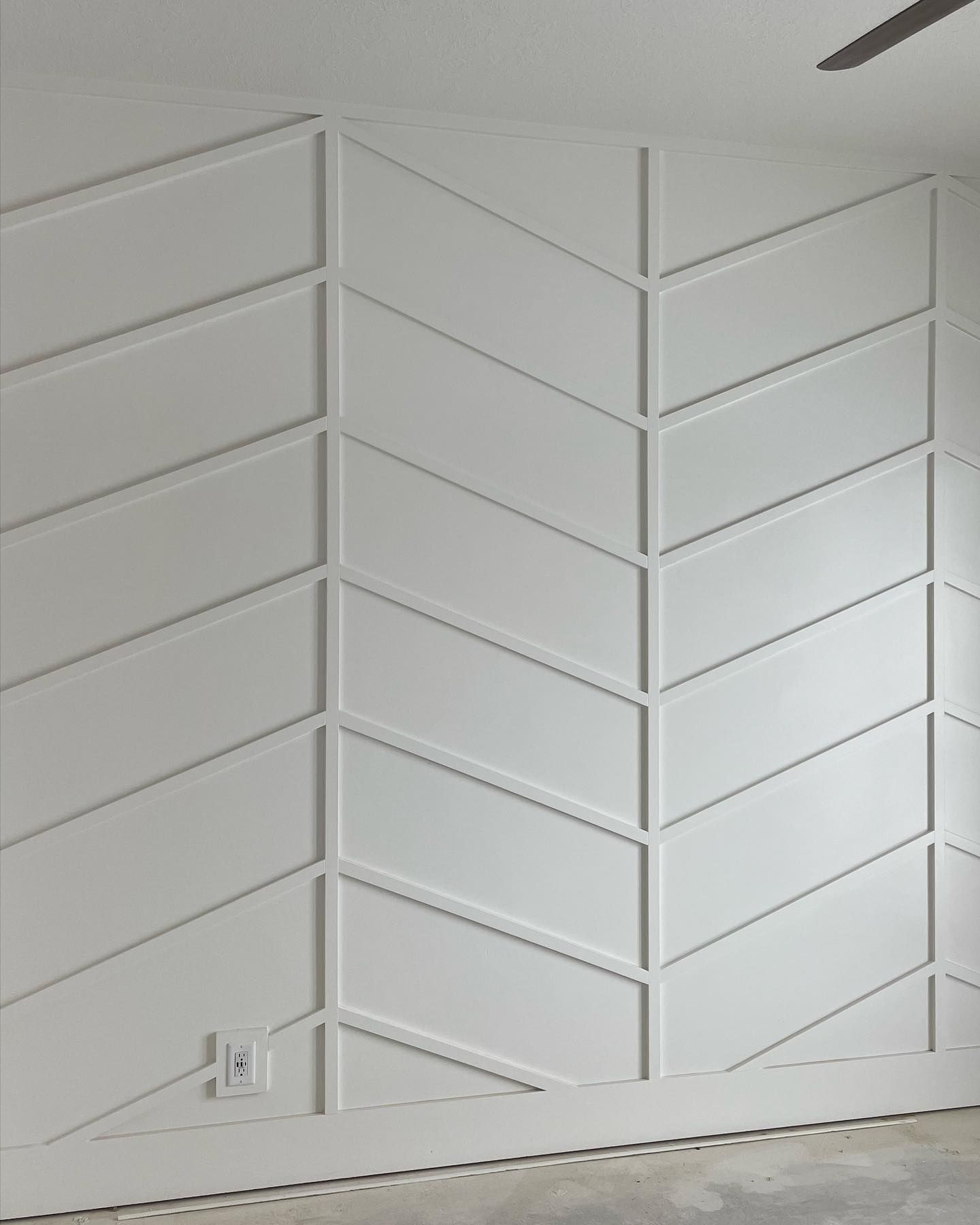 White accent wall with chevron pattern trim.