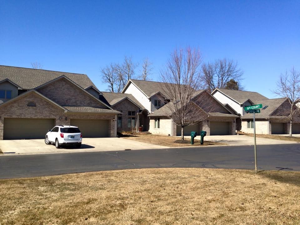 A white suv is parked in front of a row of houses