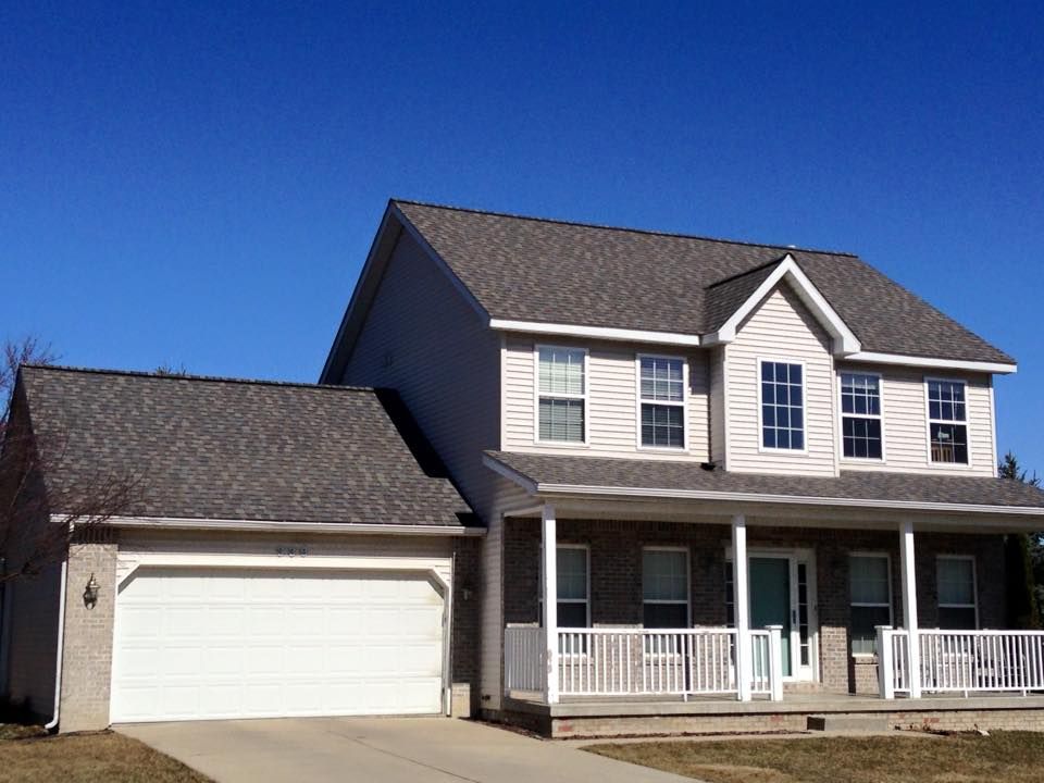 A large house with a porch and a garage