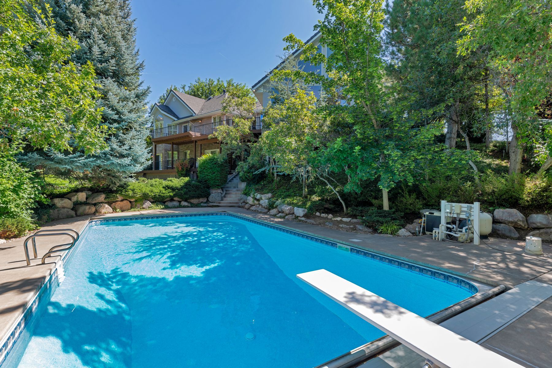 pool with a diving board in a backyard