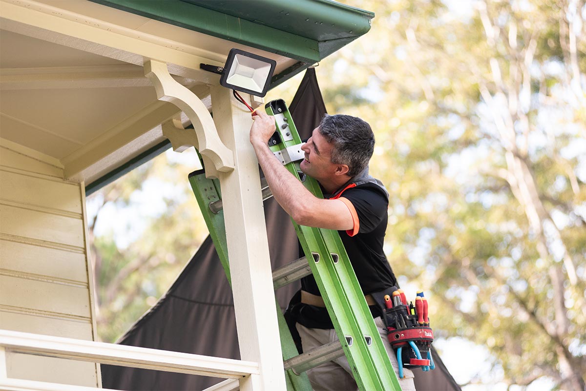 Caloundra Electrical Contractor Repairing A Light On An Extension Ladder