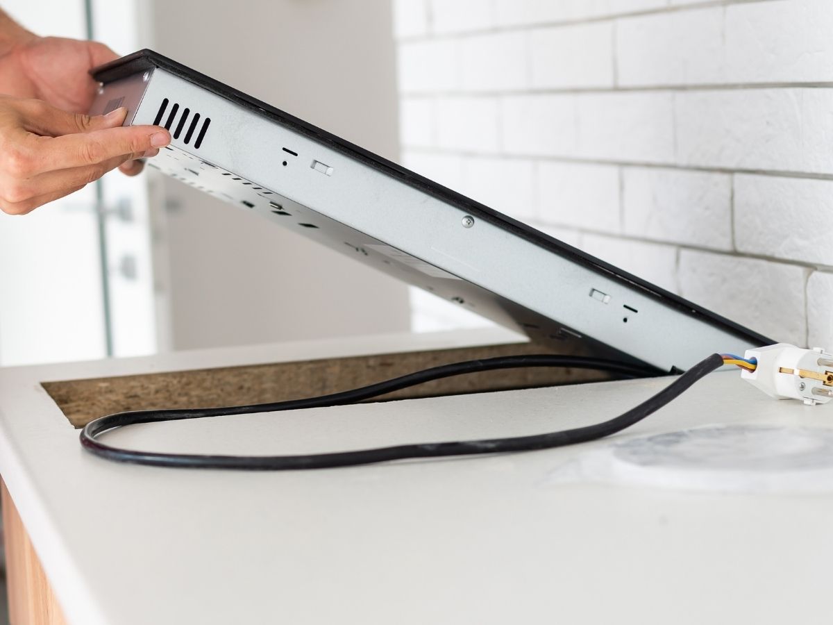 Electrician Diagnosing And Repairing Faulty Cooktop Wiring Issues Sunshine Coast