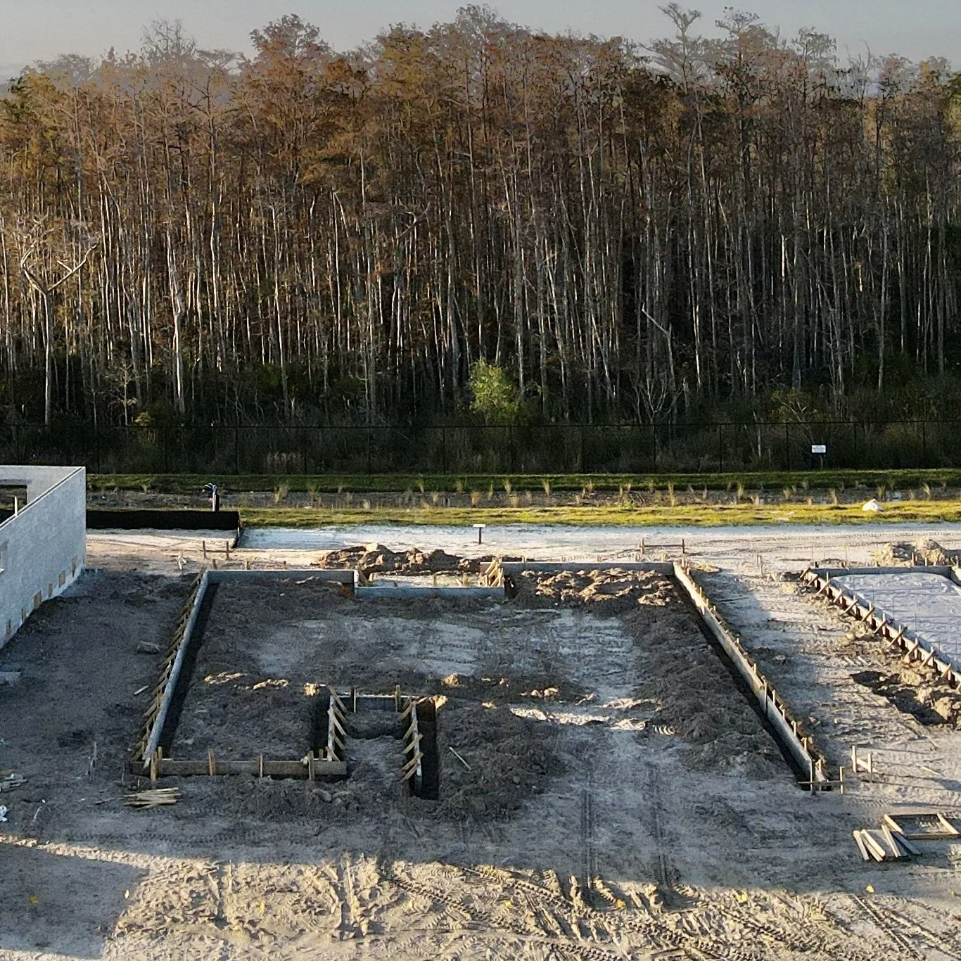 A construction site with a lot of dirt and trees in the background