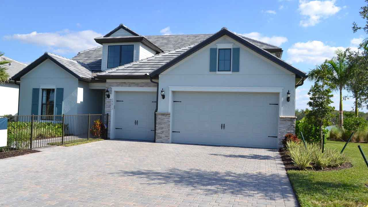 A large house with two garage doors and a driveway