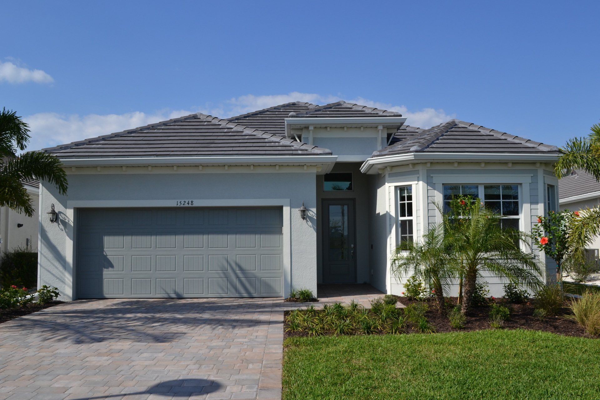 A white house with a gray garage door and a gray roof