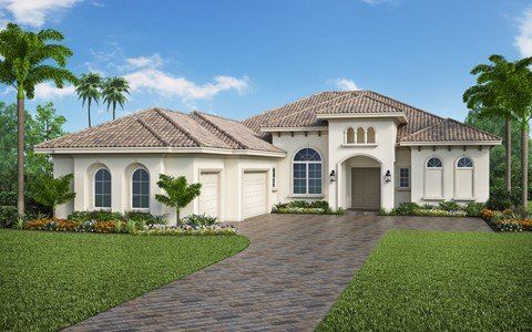 A large white house with a tile roof and a brick driveway.