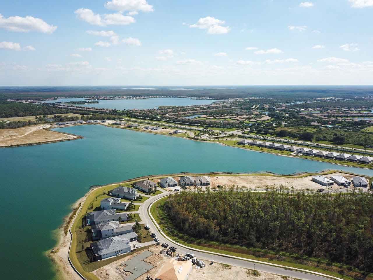 An aerial view of a lake surrounded by houses and trees.