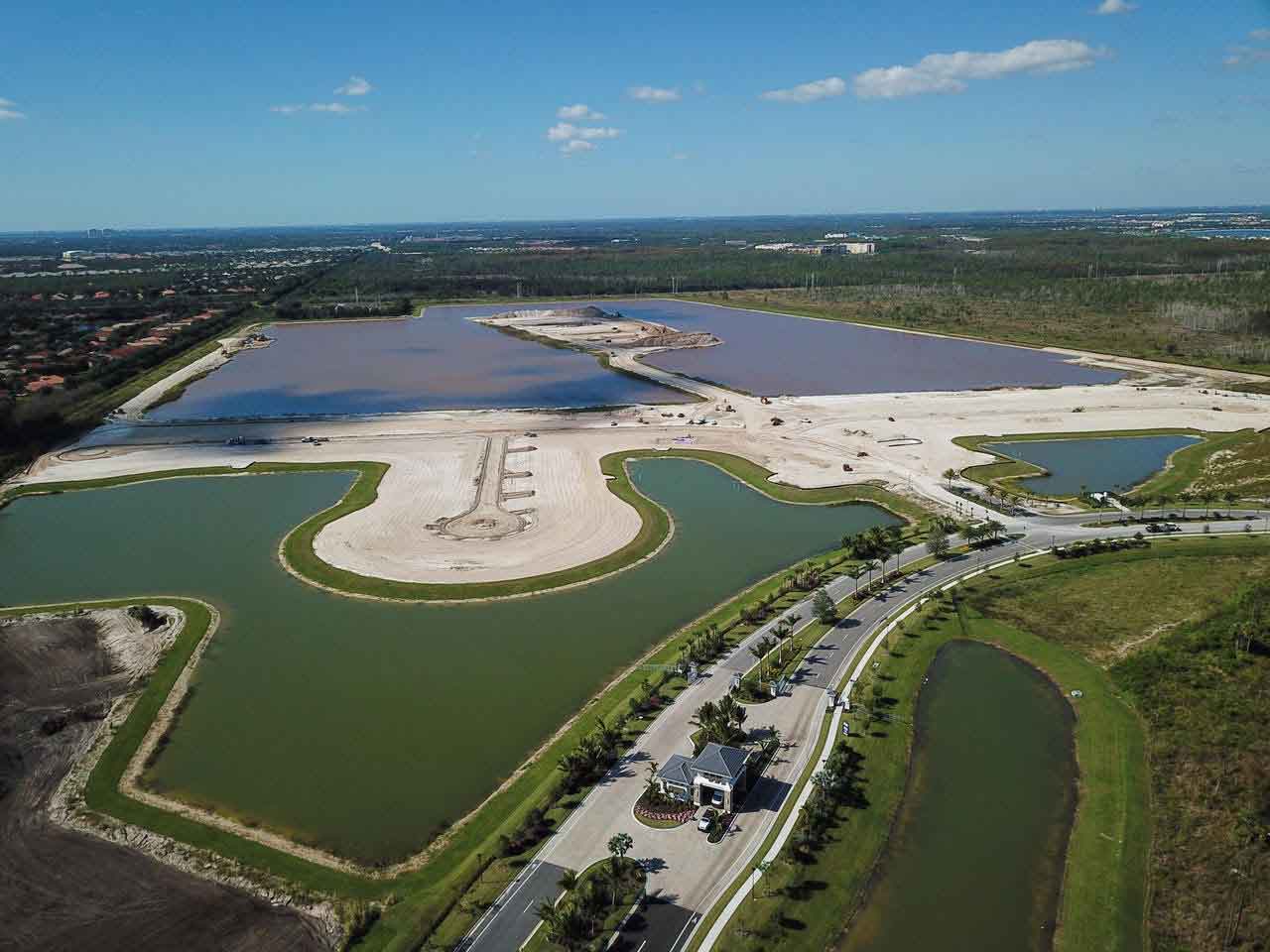An aerial view of a large body of water surrounded by grass and trees.