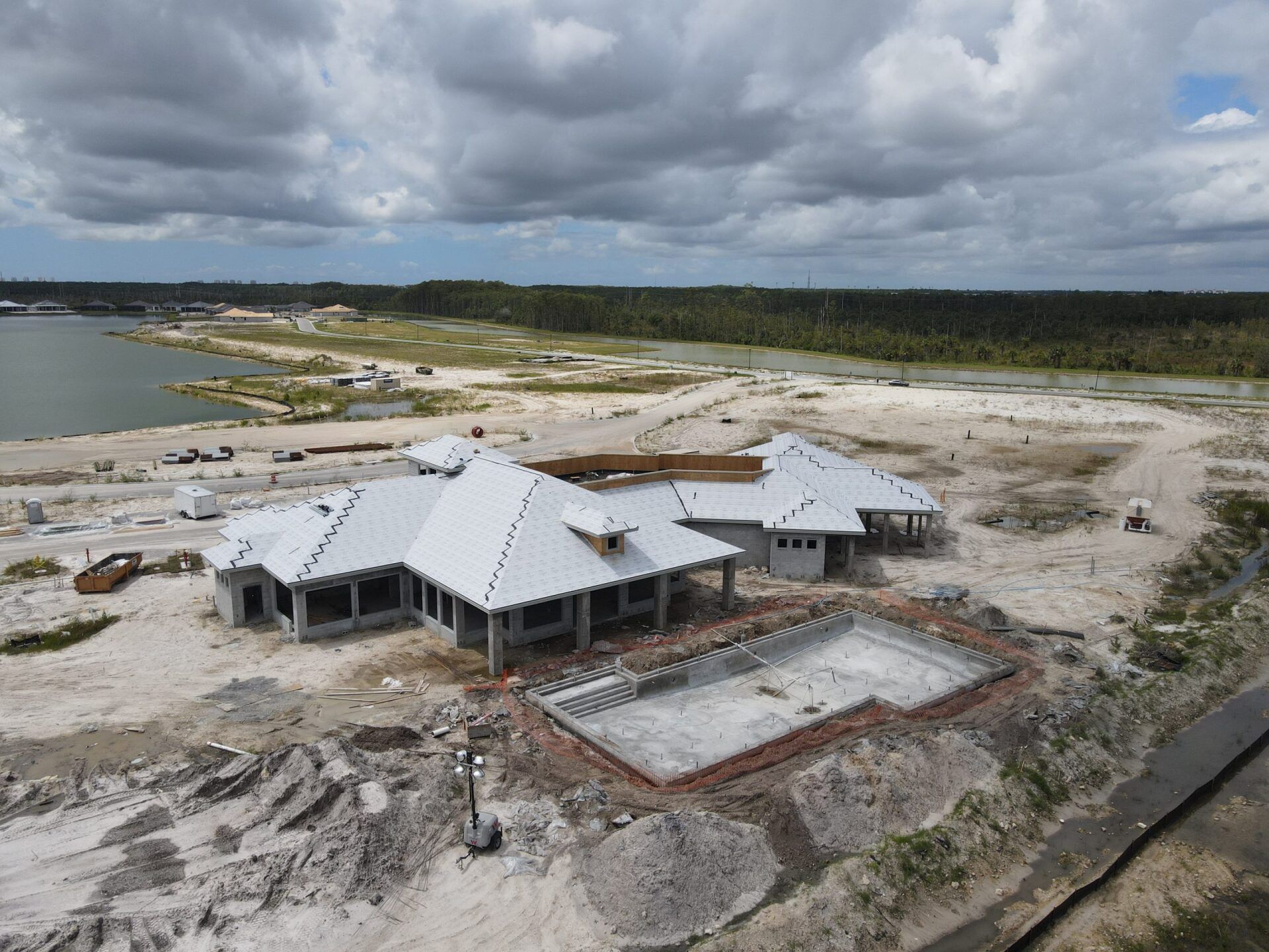An aerial view of a house under construction next to a body of water.