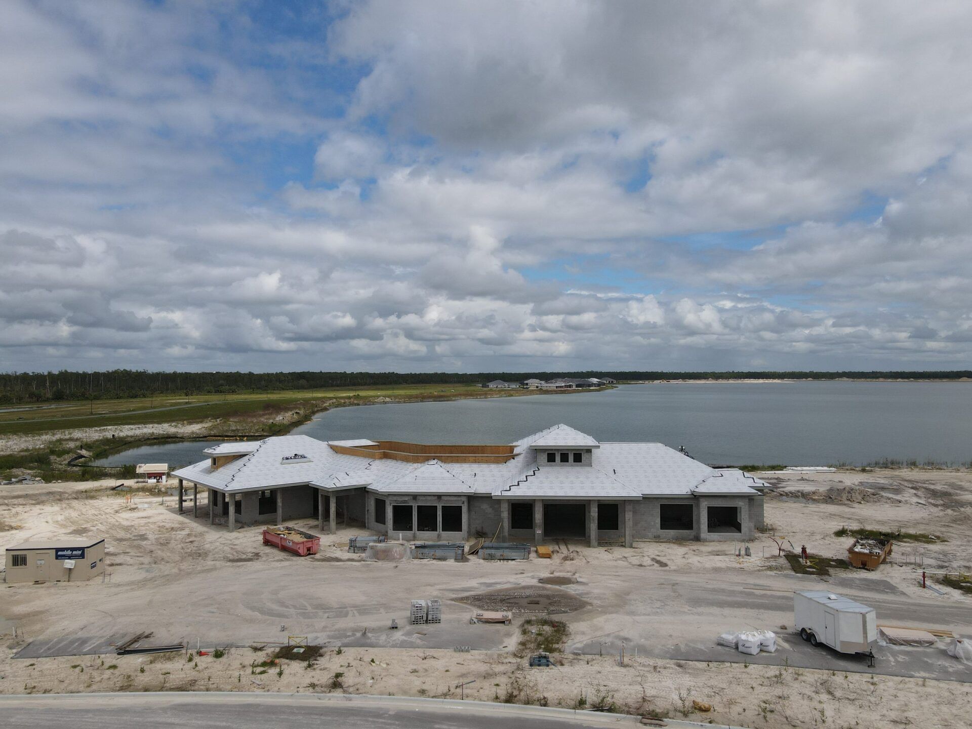 An aerial view of a house under construction next to a lake.