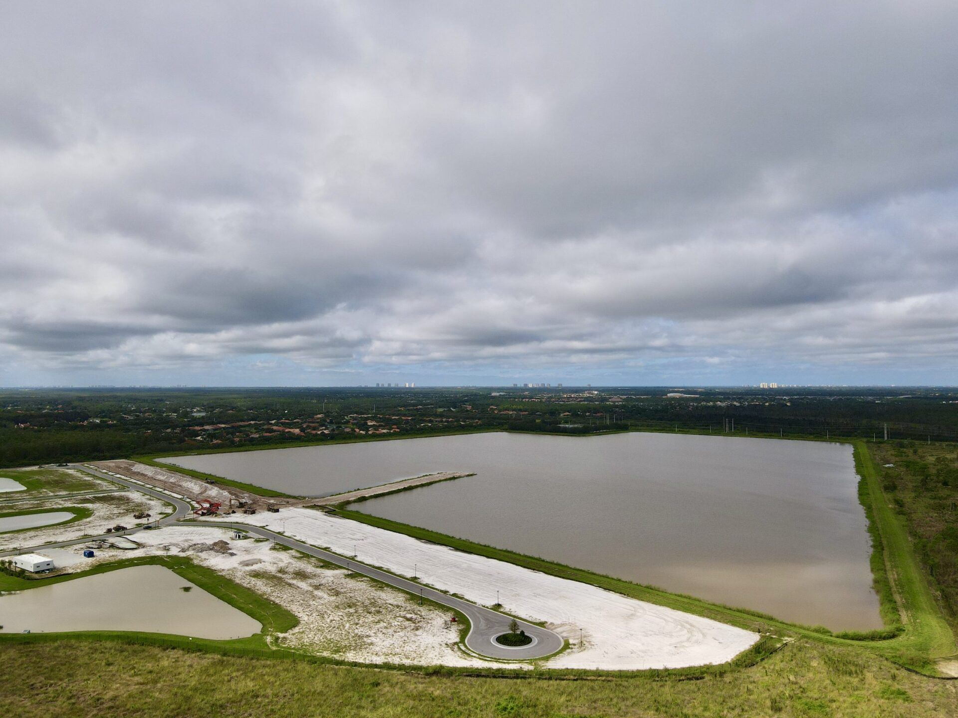 An aerial view of a large body of water surrounded by grass and trees.