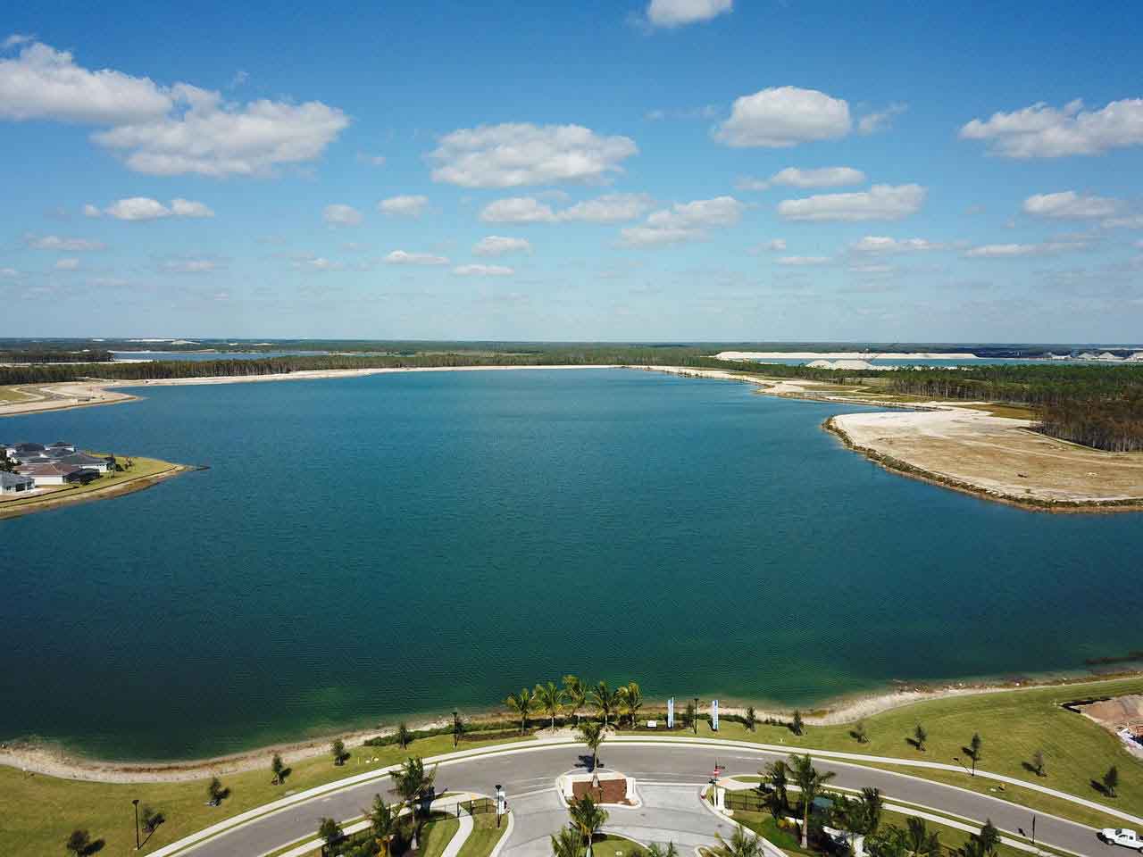 An aerial view of a large body of water surrounded by trees and grass.
