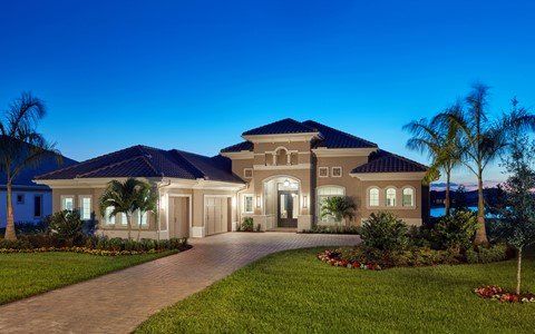 A large house with a driveway and palm trees in front of it