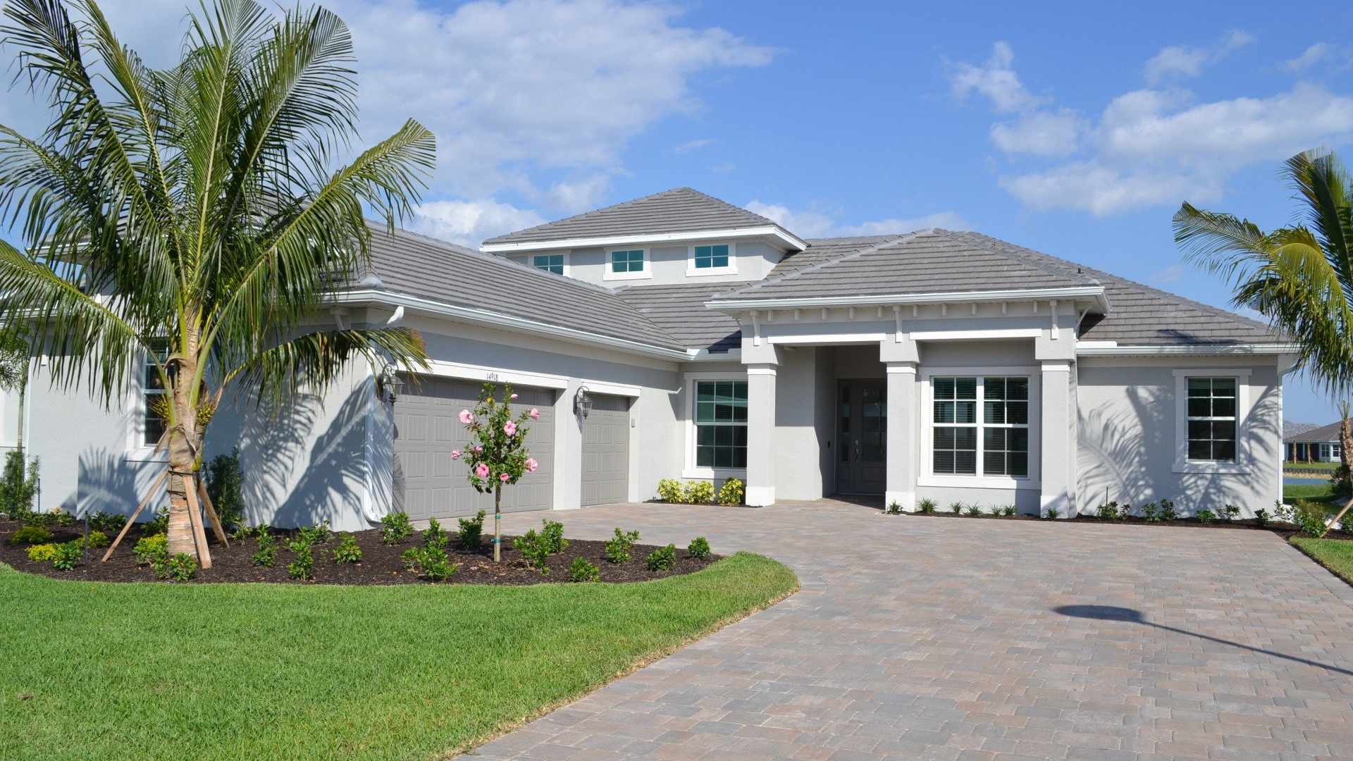 A large white house with a palm tree in front of it