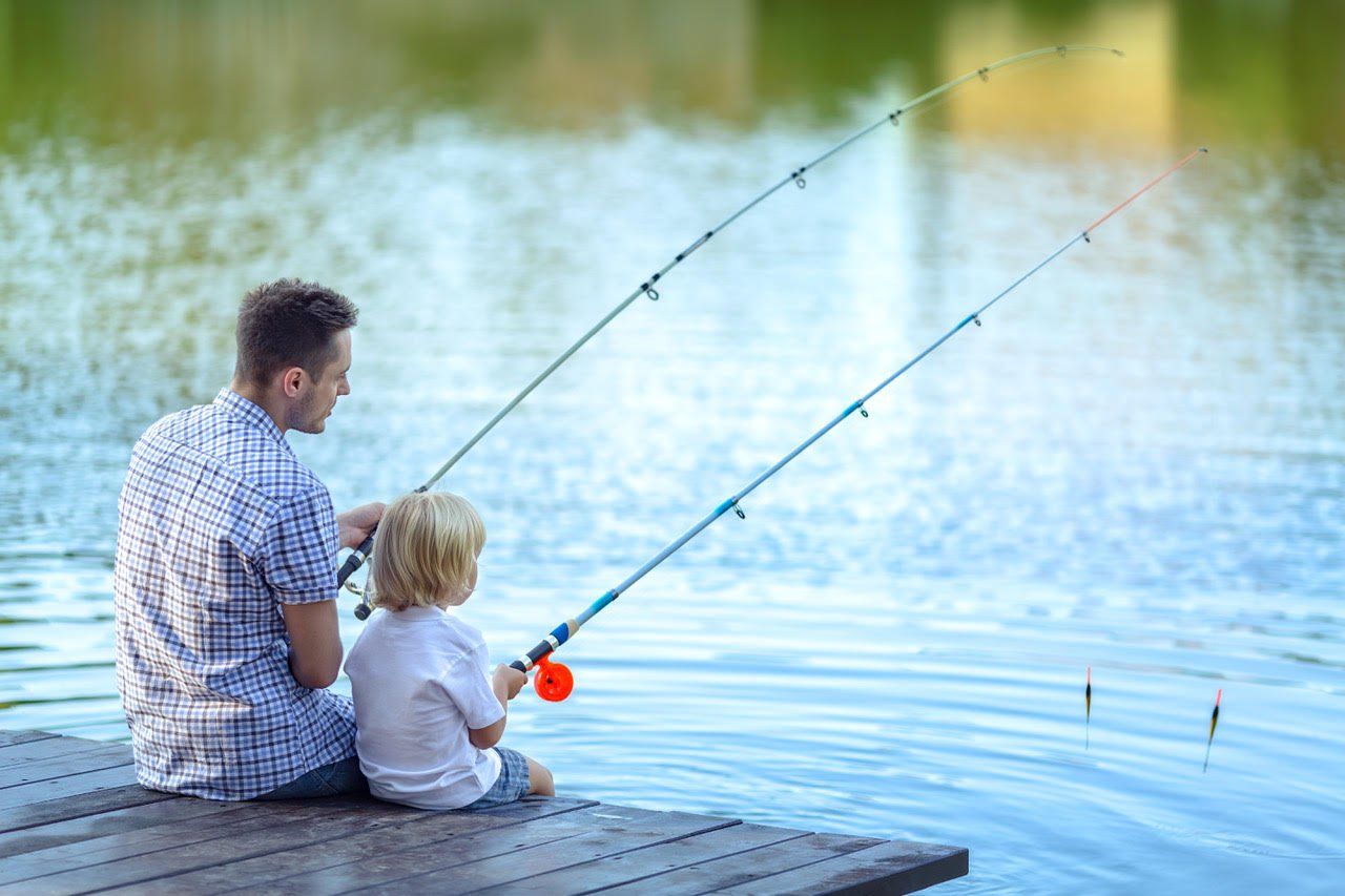 A man and a child are fishing on a dock.