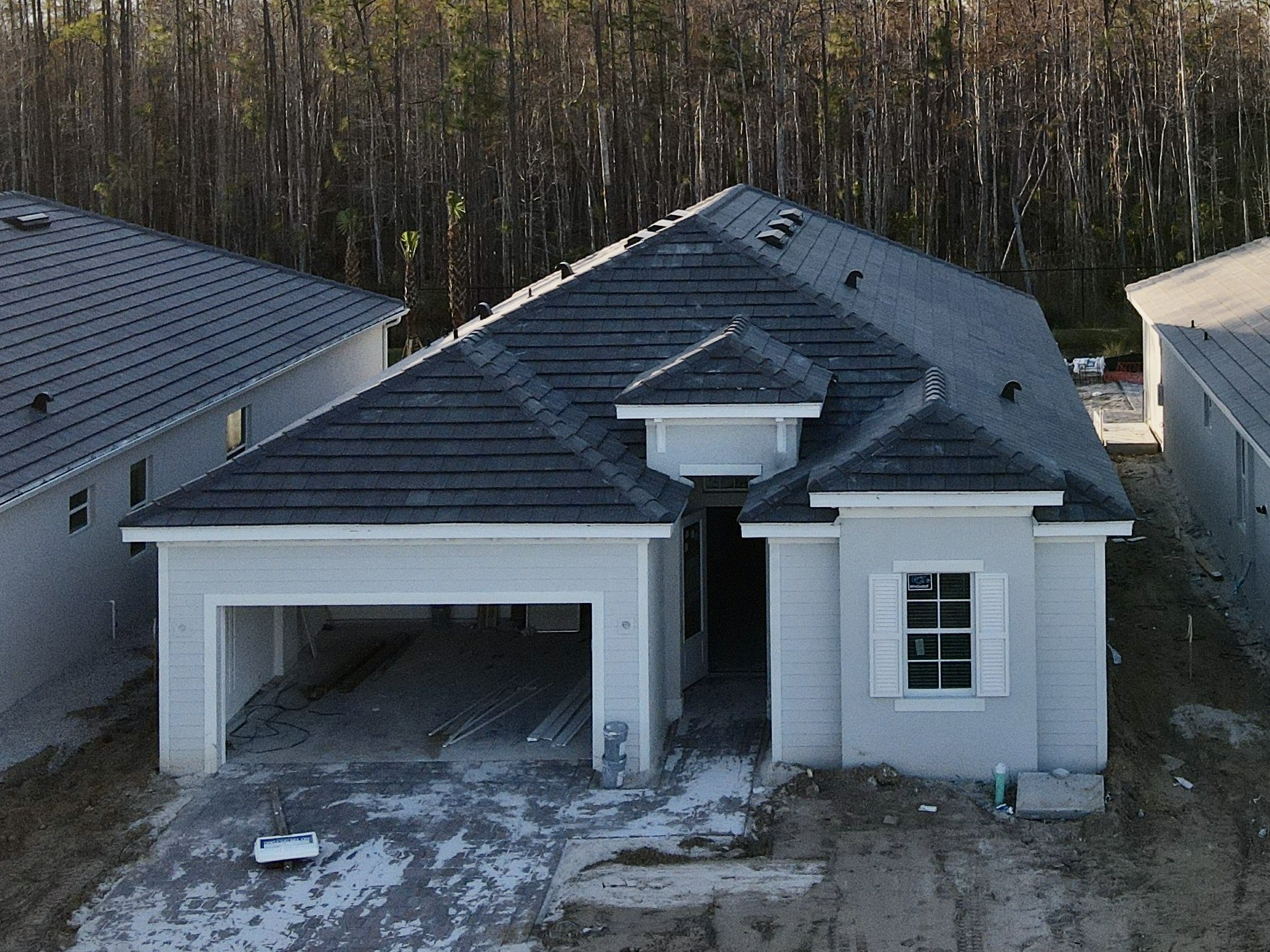 An aerial view of a house under construction with a black roof