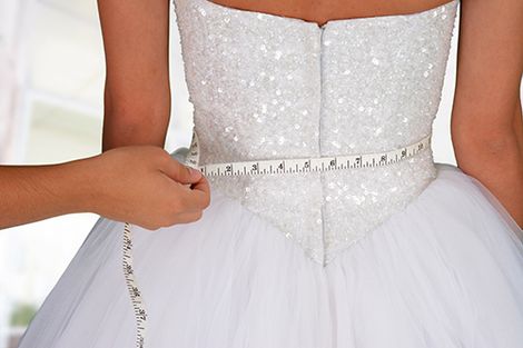 Measuring the bride for a custom bridal dress