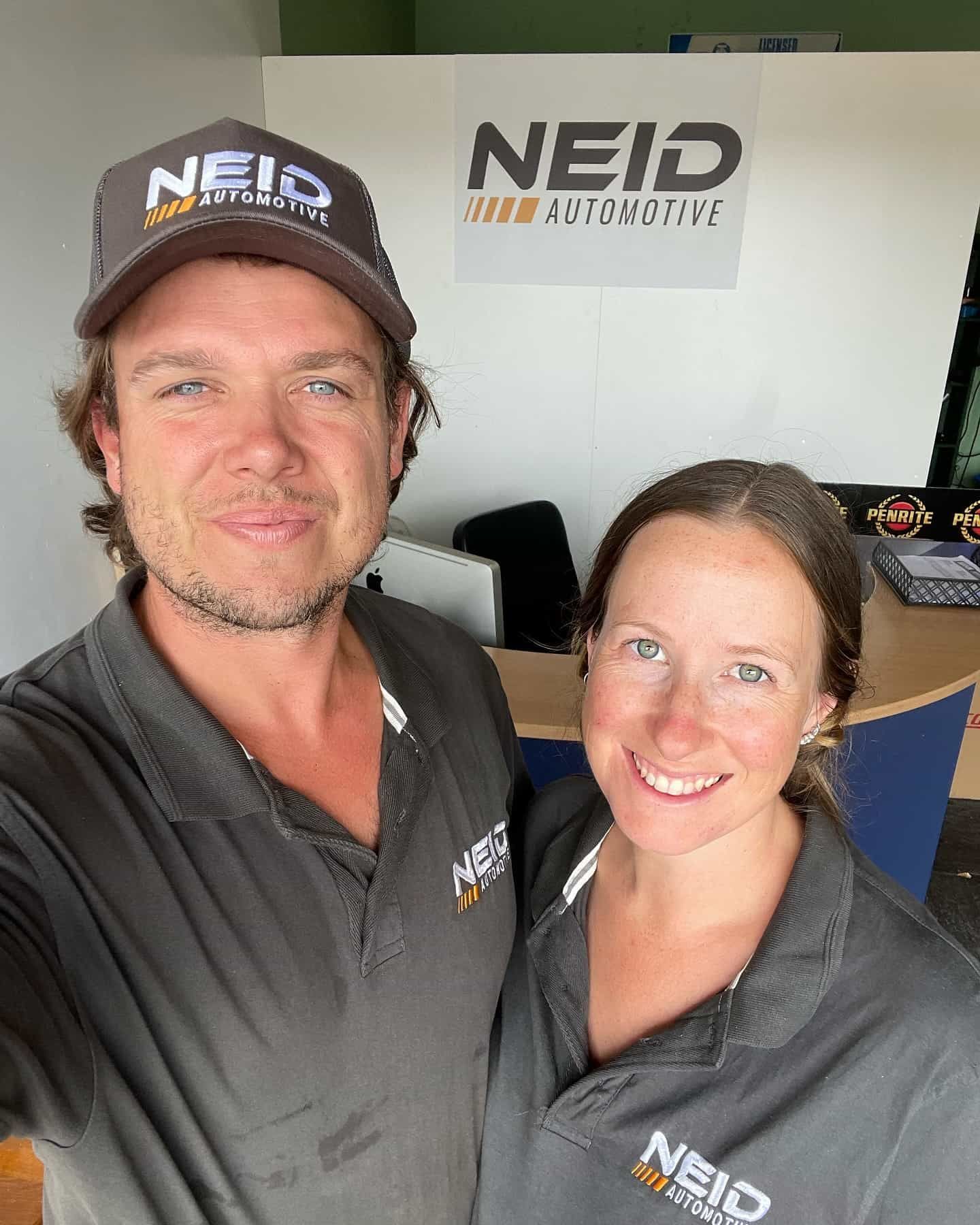 A Man And A Woman In Front Of A Sign That Says Neid Automotive — NEID Automotive In North Gosford, NSW