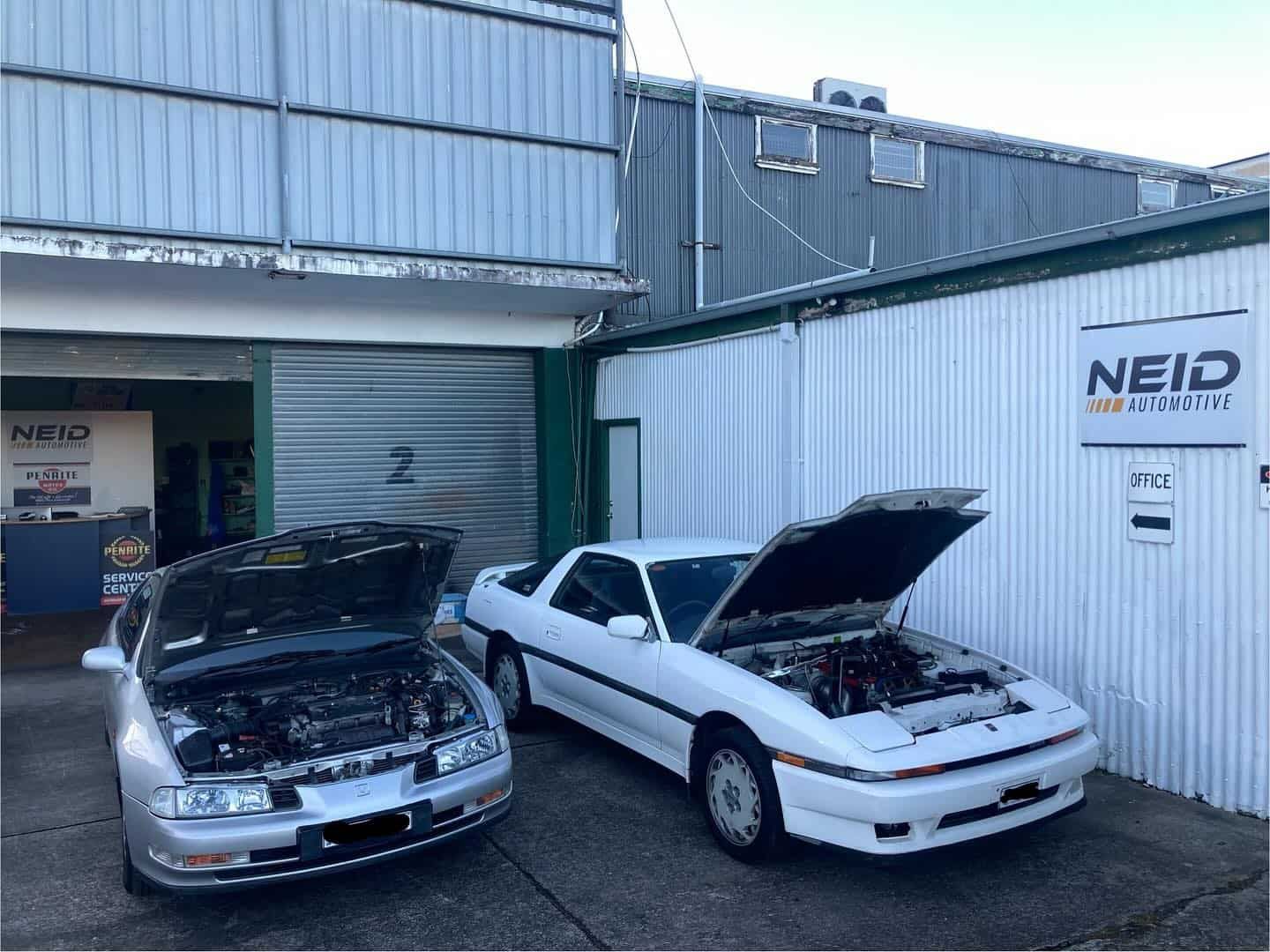 Two Cars Are Parked In Front Of A Building With Their Hoods Open — NEID Automotive In North Gosford, NSW