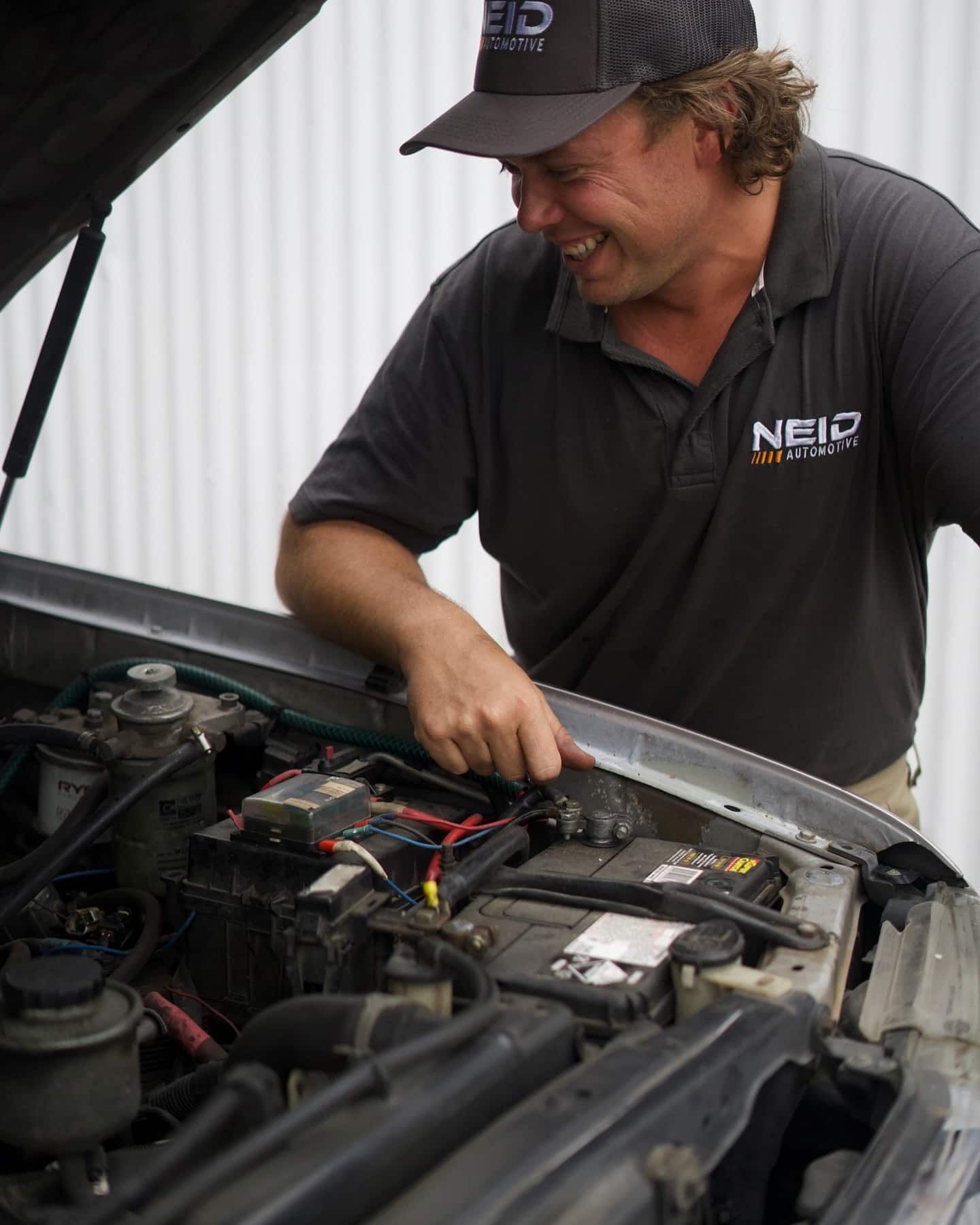 A Man Wearing A Neid Shirt Is Working On A Car — NEID Automotive In North Gosford, NSW