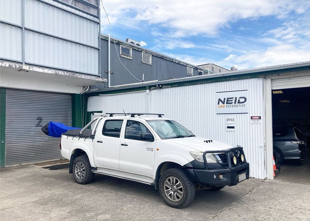 A White Truck Is Parked In Front Of A Mechanic Garage — NEID Automotive In North Gosford, NSW