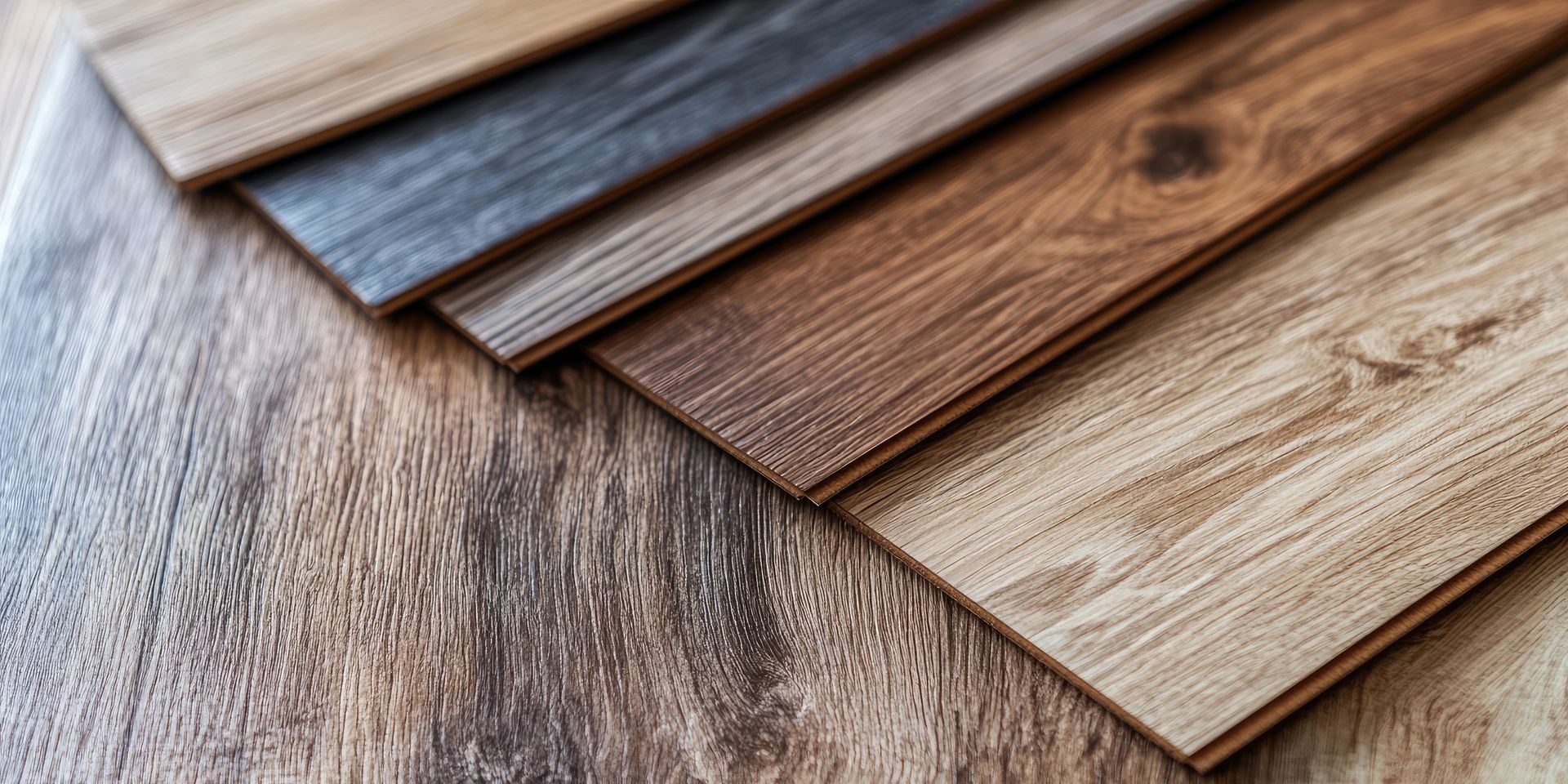 Wood flooring samples in various colors arranged on a matching wood surface Wood flooring samples in various colors arranged on a matching wood surface