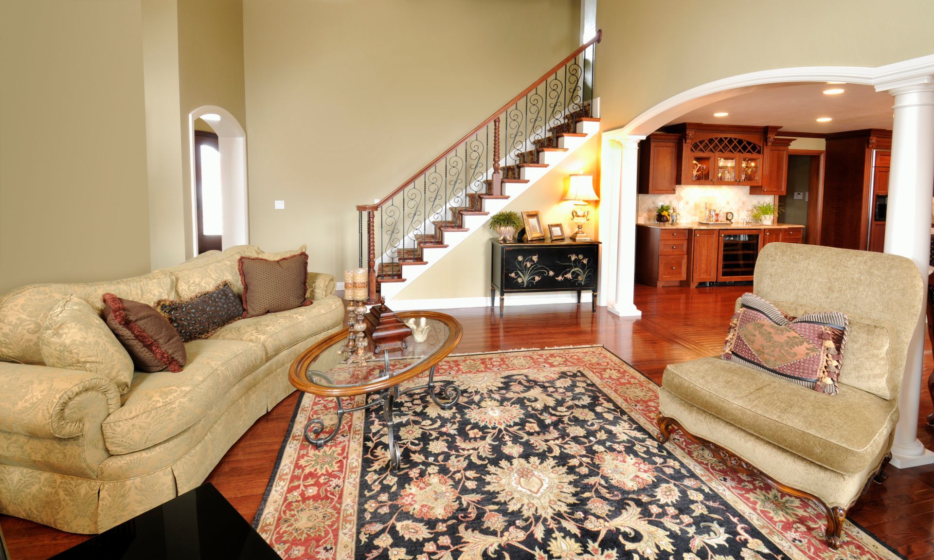 A living room with a staircase, a couch and a Custom rugs