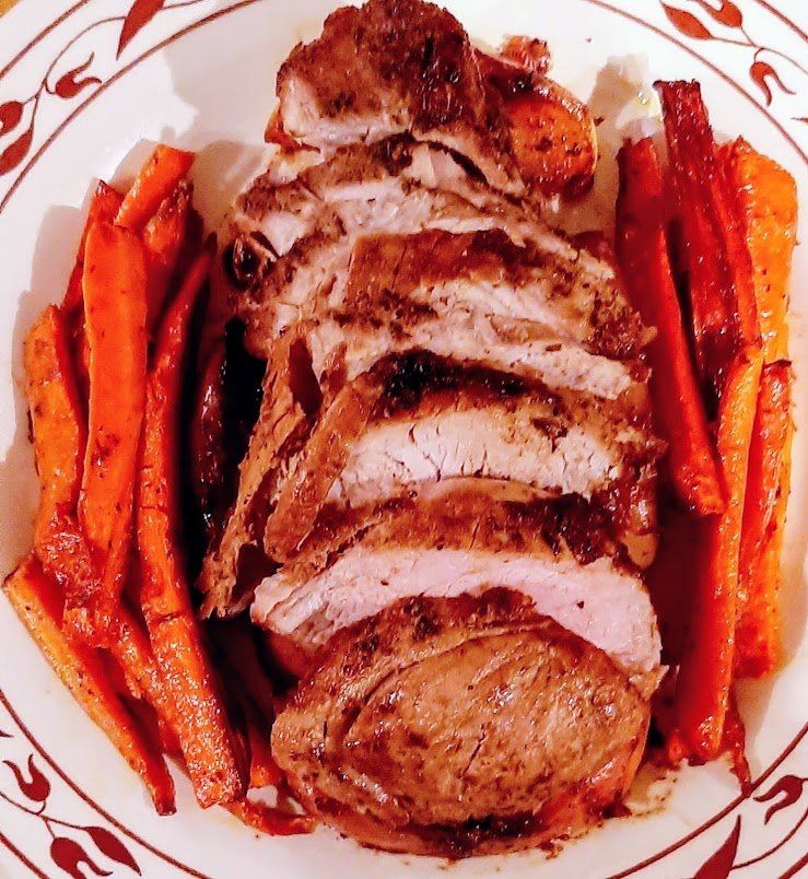 A white plate topped with sliced meat and carrots