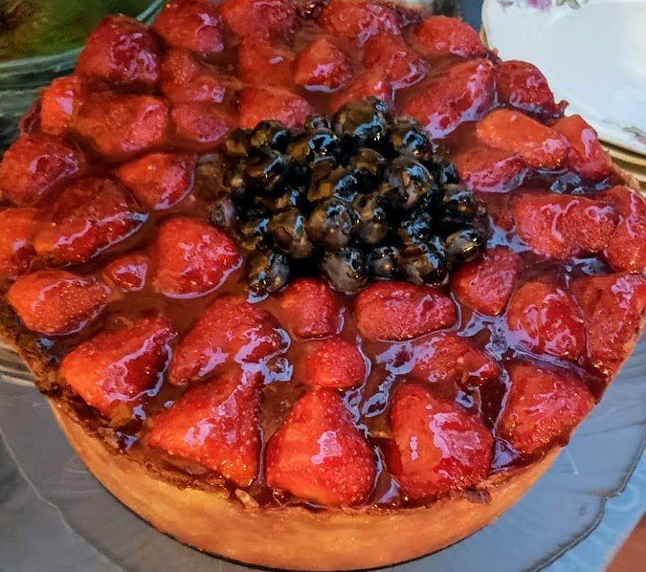 A pie with strawberries and blueberries on top