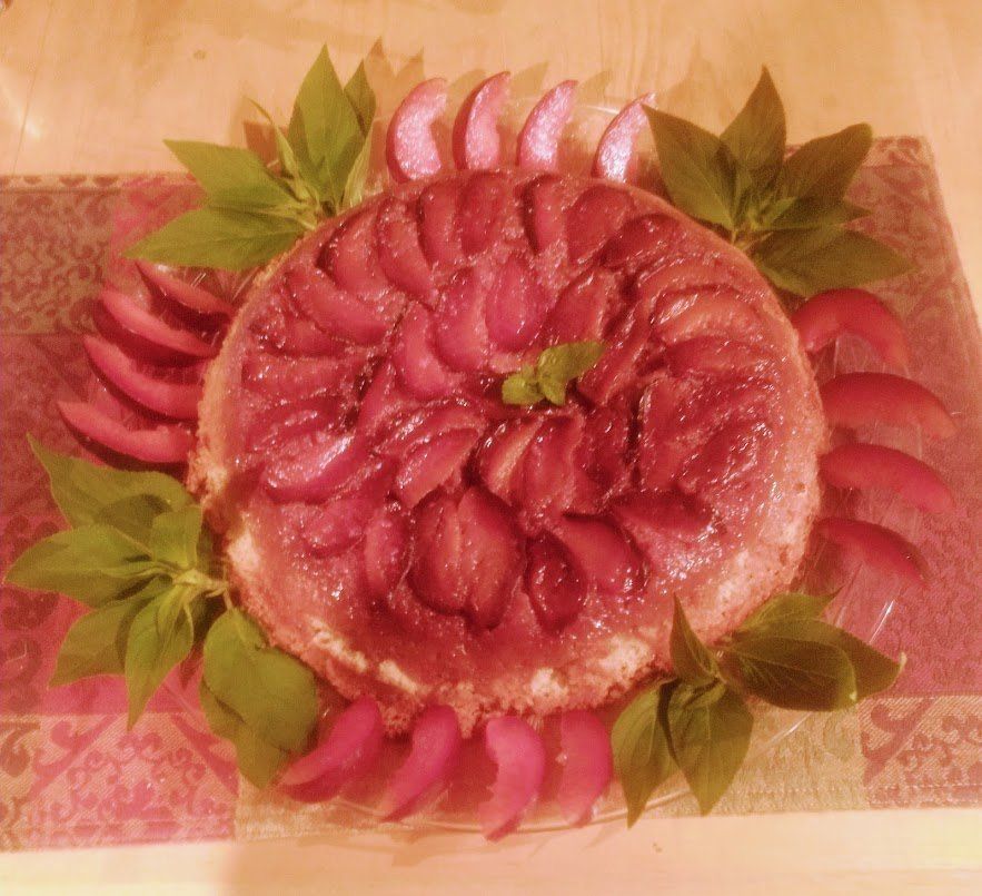 A cake decorated with leaves and fruit on a table