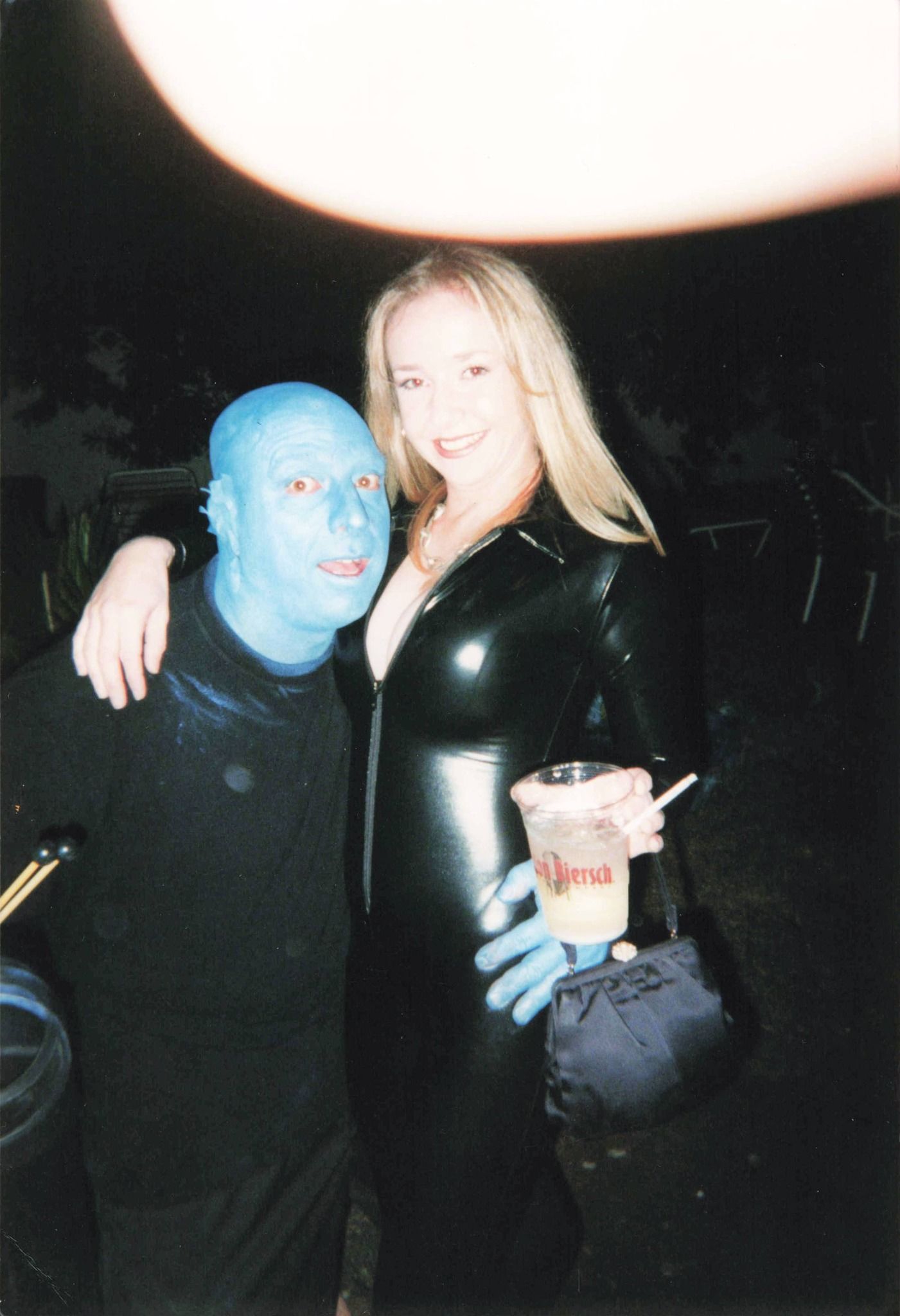 A man with blue paint on his face is standing next to a woman