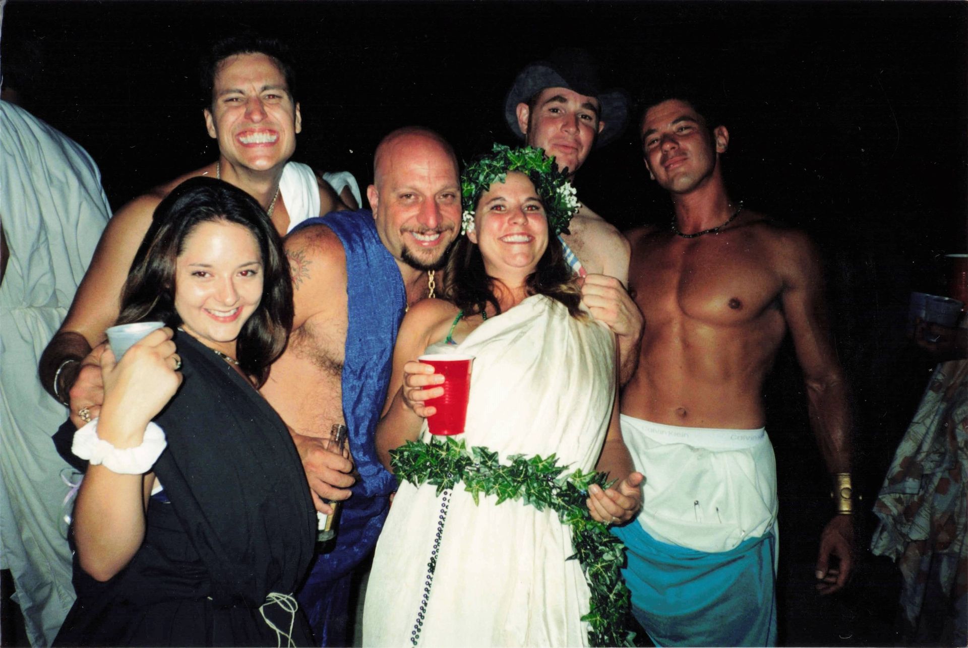 A group of people posing for a picture with one woman holding a red cup