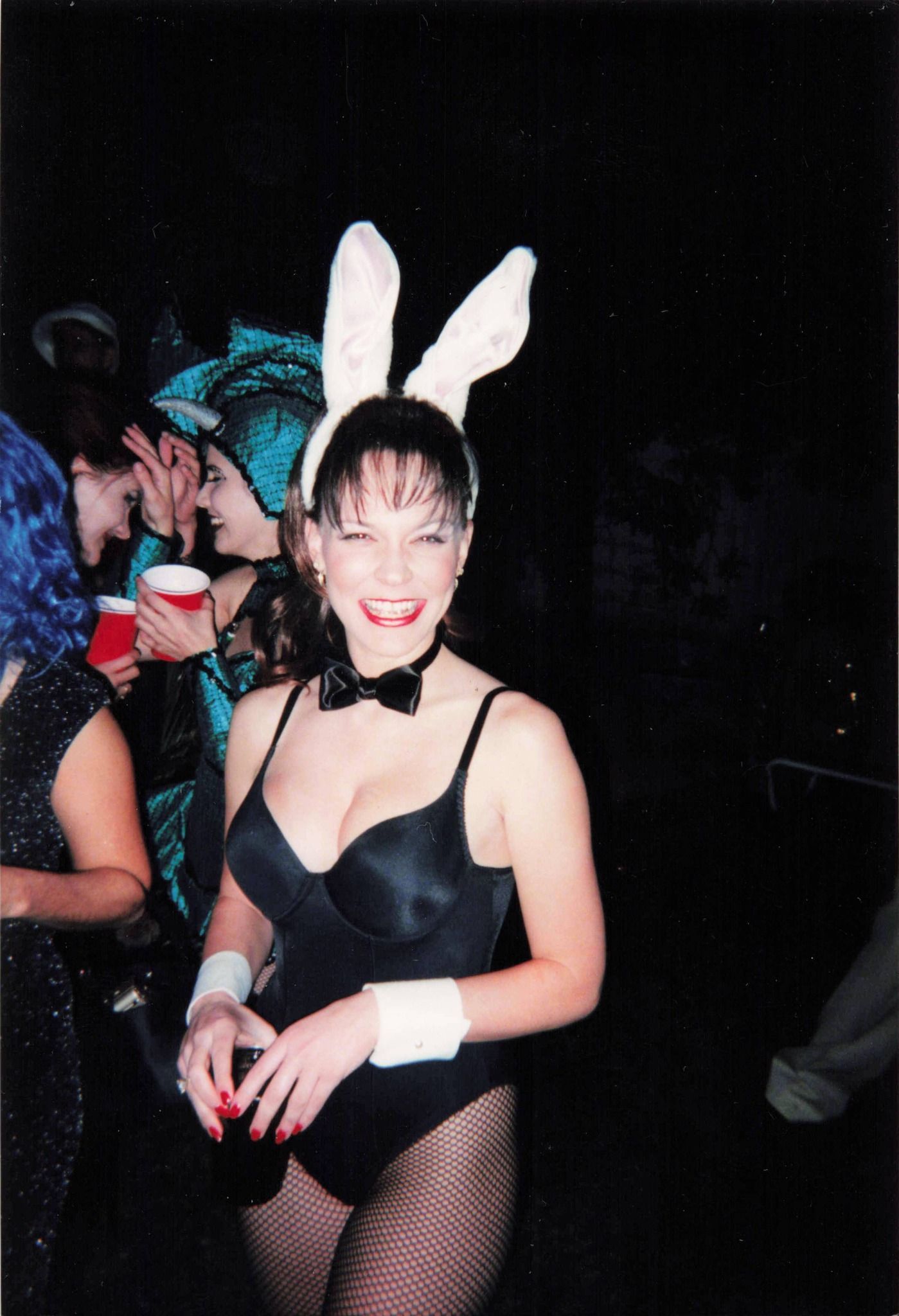 A woman in a black bodysuit with white bunny ears