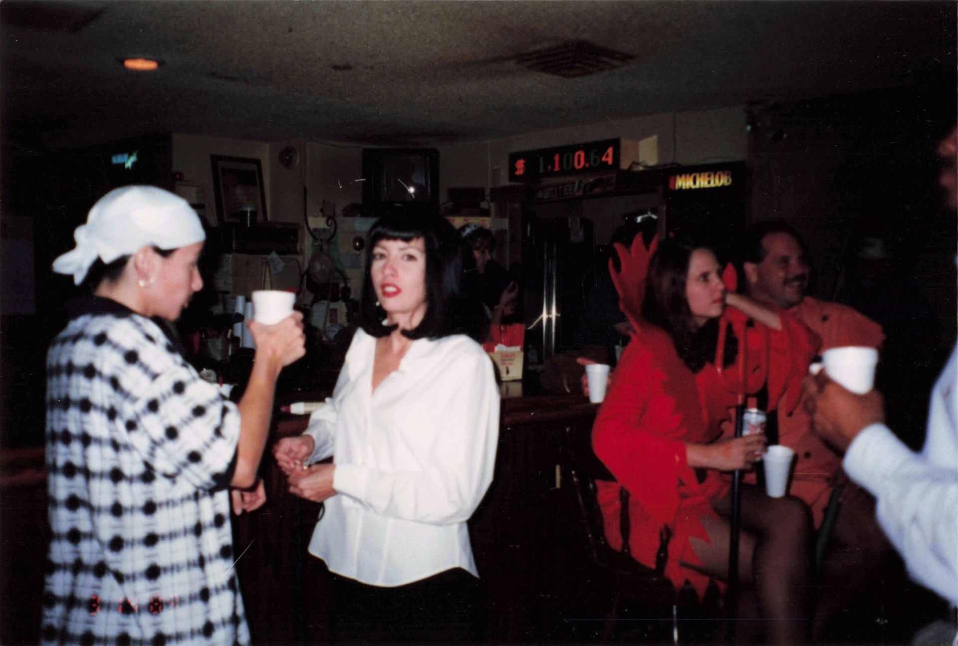A group of people standing around a bar drinking coffee