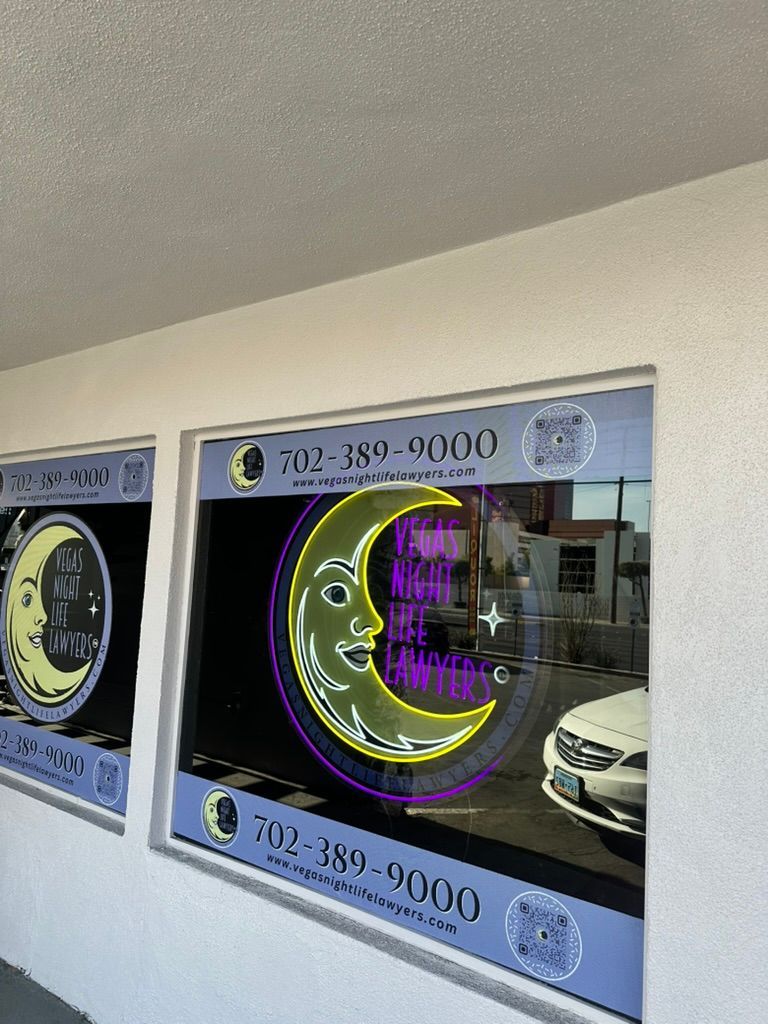 A window with a neon crescent moon on it