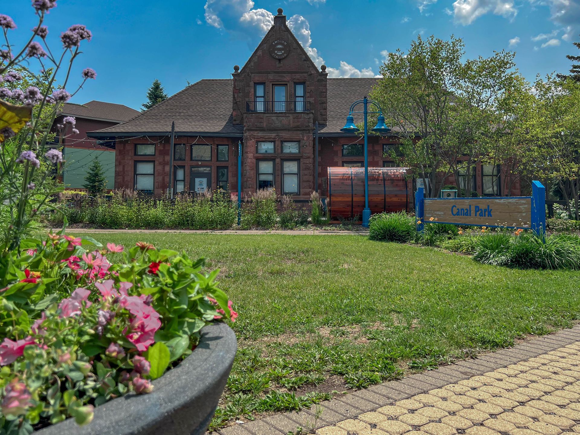 A large brick building with flowers in front of it.
