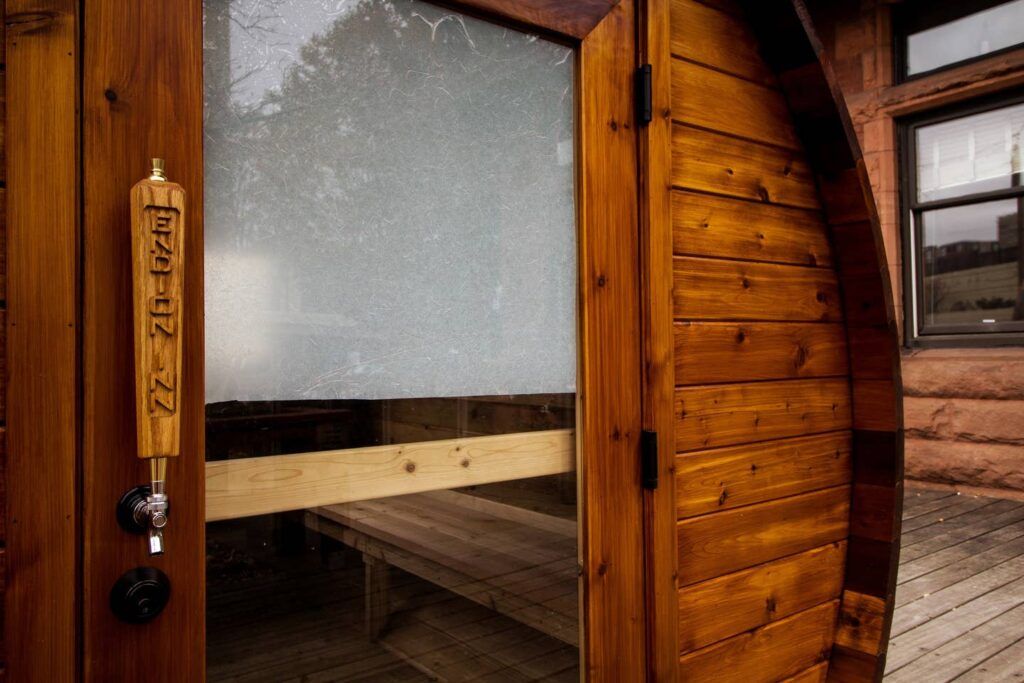 A wooden door with a glass window and a wooden handle.