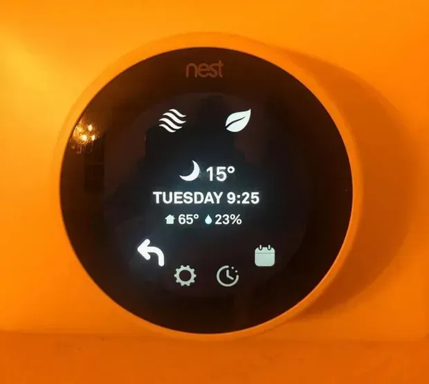 A round Nest thermostat display shows current indoor temperature 65 degrees, 23% humidity, and a 15-degree outdoor reading.