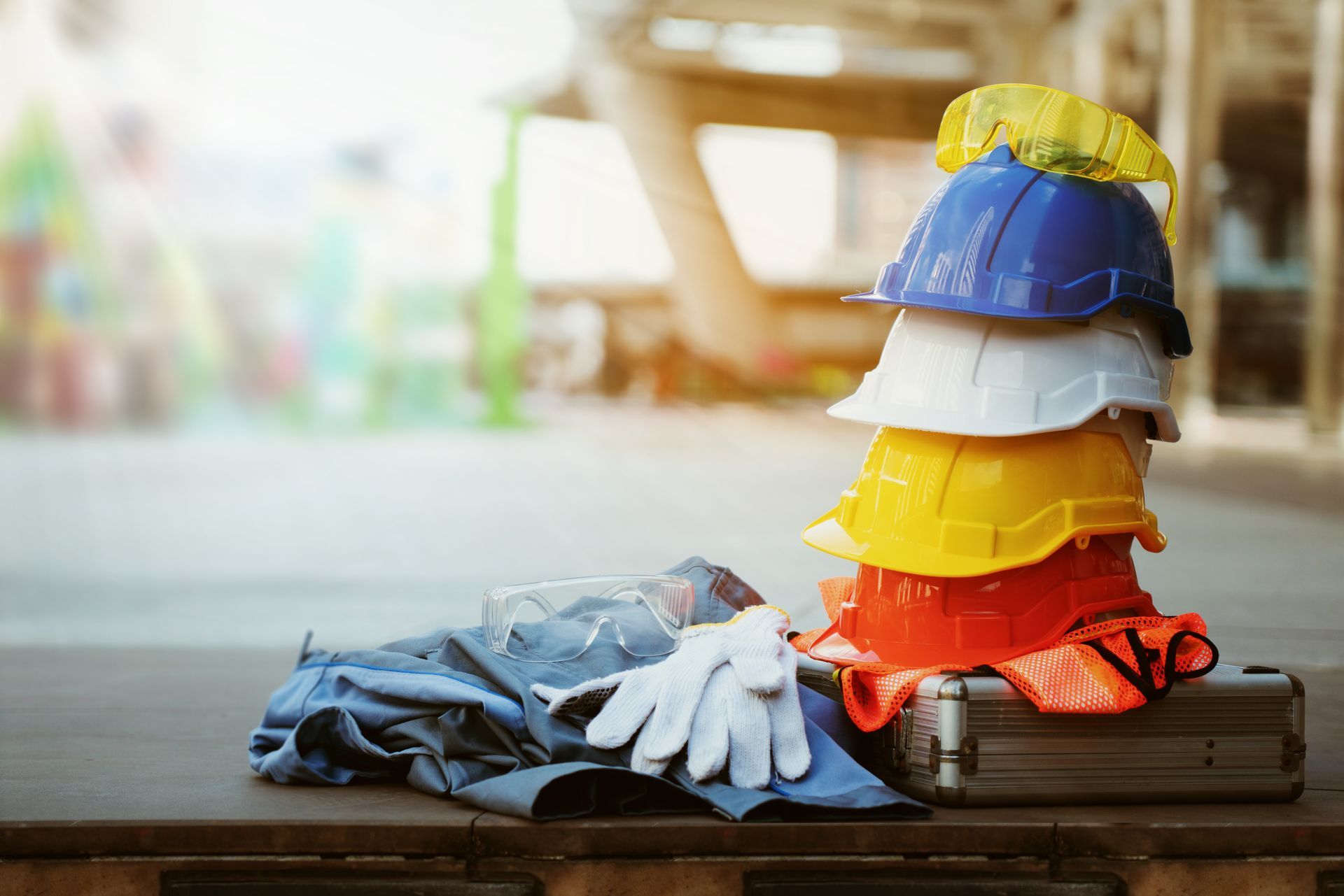 Stack of safety helmets with gloves, goggles, and gear on a worksite table. Stack of safety helmets with gloves, goggles, and gear on a worksite table.