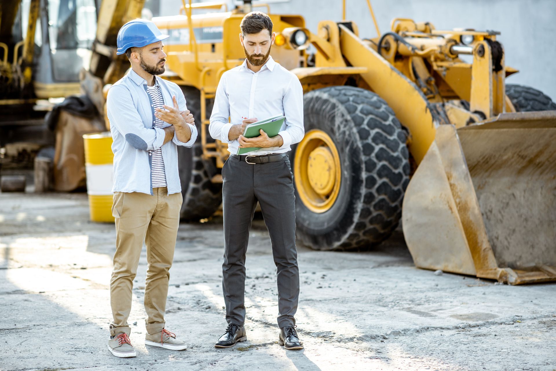Builder choosing heavy machinery for construction with a sales consultant. Builder choosing heavy machinery for construction with a sales consultant.