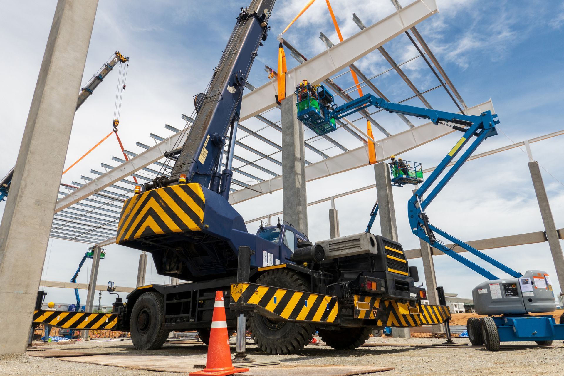Steel roof structure installation using a mobile crane from a local equipment supplier.