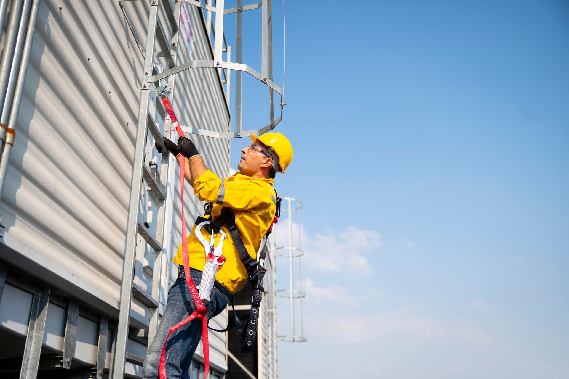 Construction worker wearing safety harness and safety line working at high place.